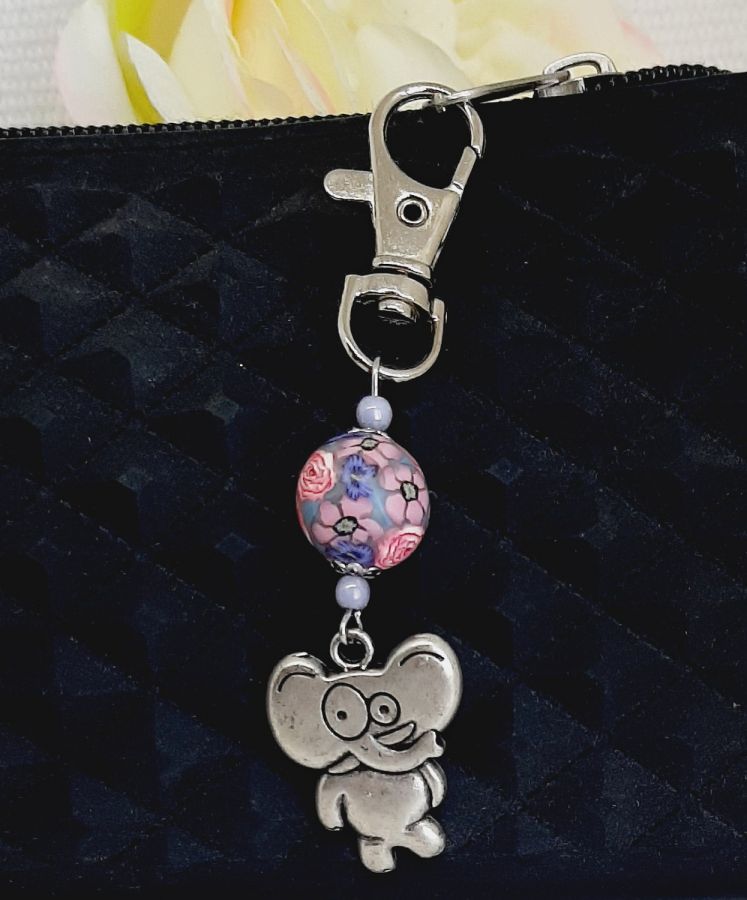 versilberter Schlüsselanhänger mit stilisiertem Elefanten Humor und handgefertigter Perle in rosa und lila