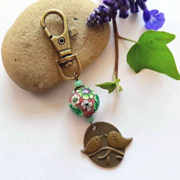 schl&uuml;sselanh&auml;nger medaille duo vogel bronzefarben und handgefertigte perle floralmotiv gr&uuml;n und weinrotmulticolore