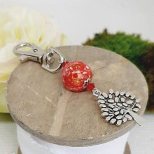 versilberter Schlüsselanhänger mit Lebensbaum-Symbol und handgefertigter Perle in leuchtendem Rot und Gold