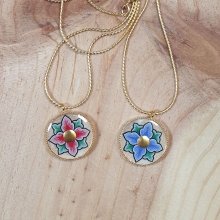 Frühlingshaft illuminierte Halskette mit rosa oder blauen Blumen an einer goldenen Kette
