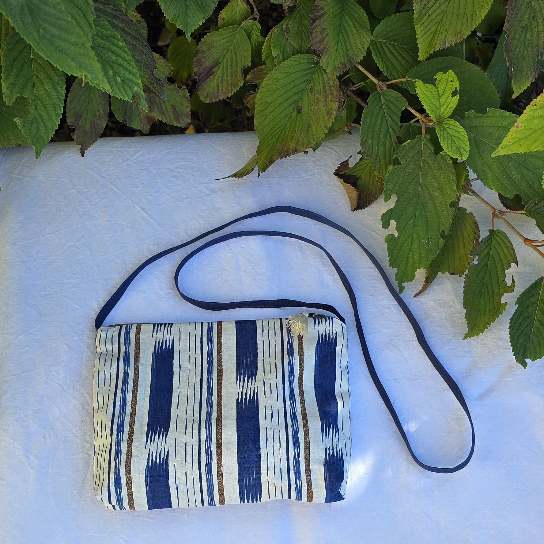 Pochette avec bandouli&egrave;re en tissu coton bleu et marron agr&eacute;ment&eacute;e d'un pompon