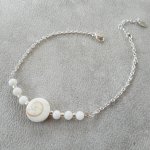 Armband aus Stearinauge und Perlmuttperlen an einer Kette aus Silber 925