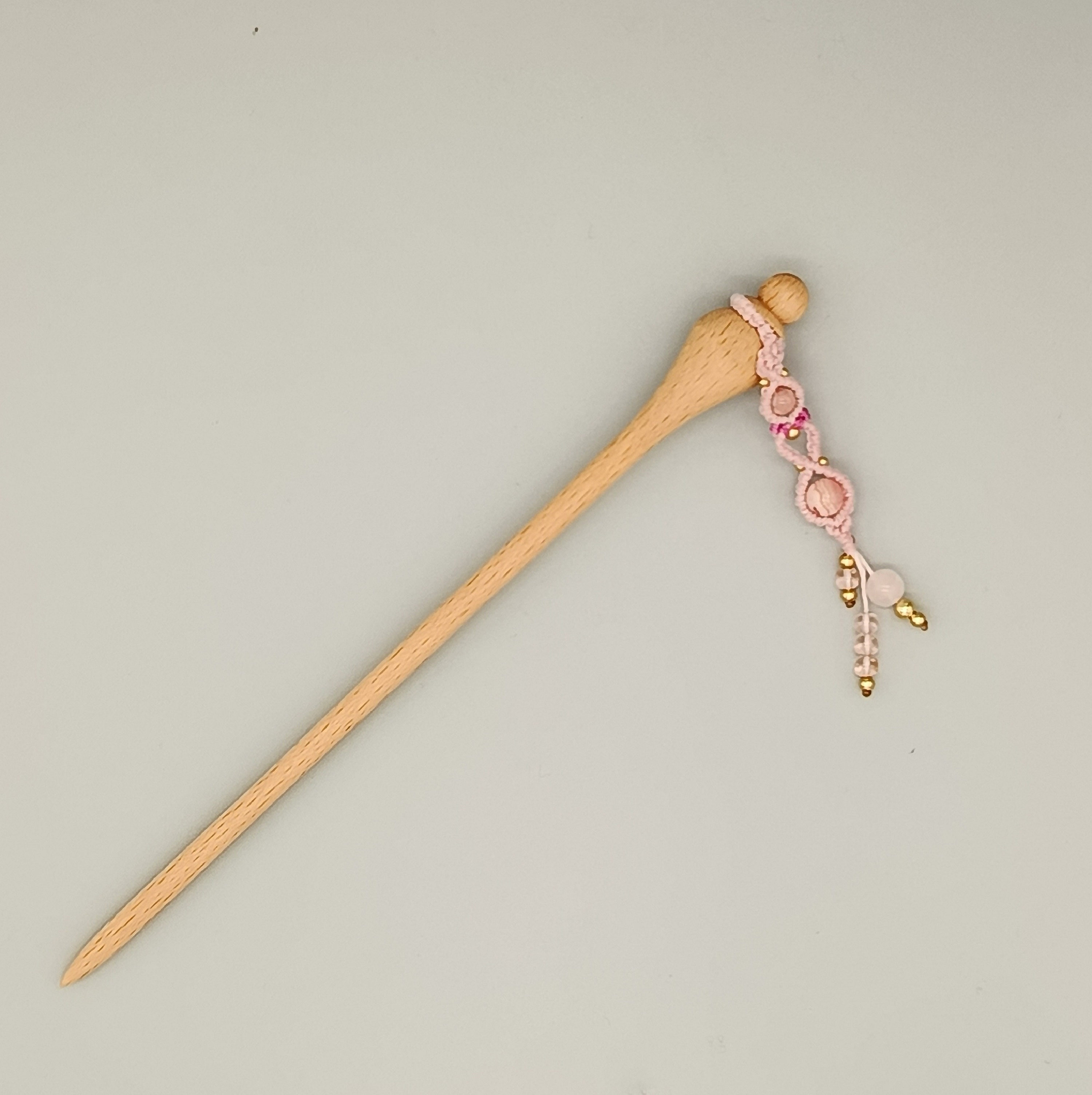 Pic à cheveux en hêtre avec ornement en micro-macramé rose.