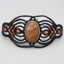 Manchette noire en micro-macramé avec une pierre de soleil