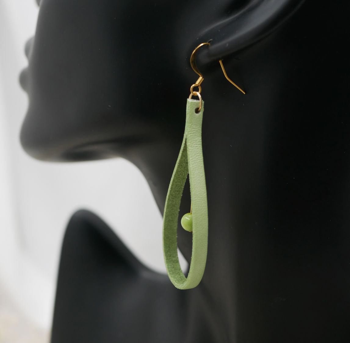Ohrringe aus mandelgrünem Leder und blassgrünen Edelsteinen