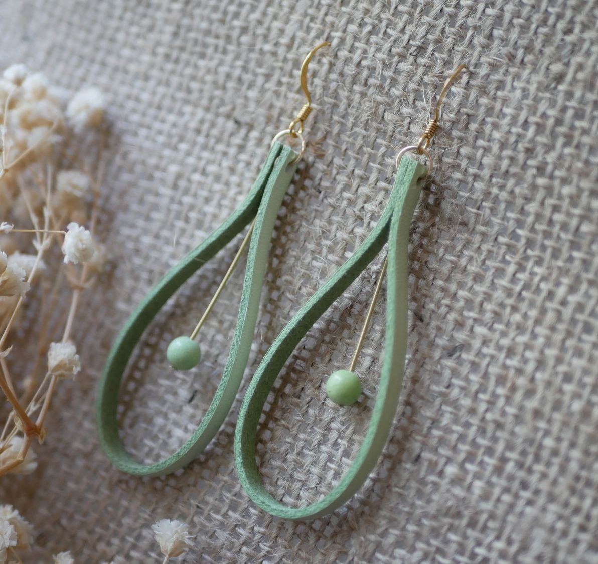 Ohrringe aus mandelgrünem Leder und blassgrünen Edelsteinen