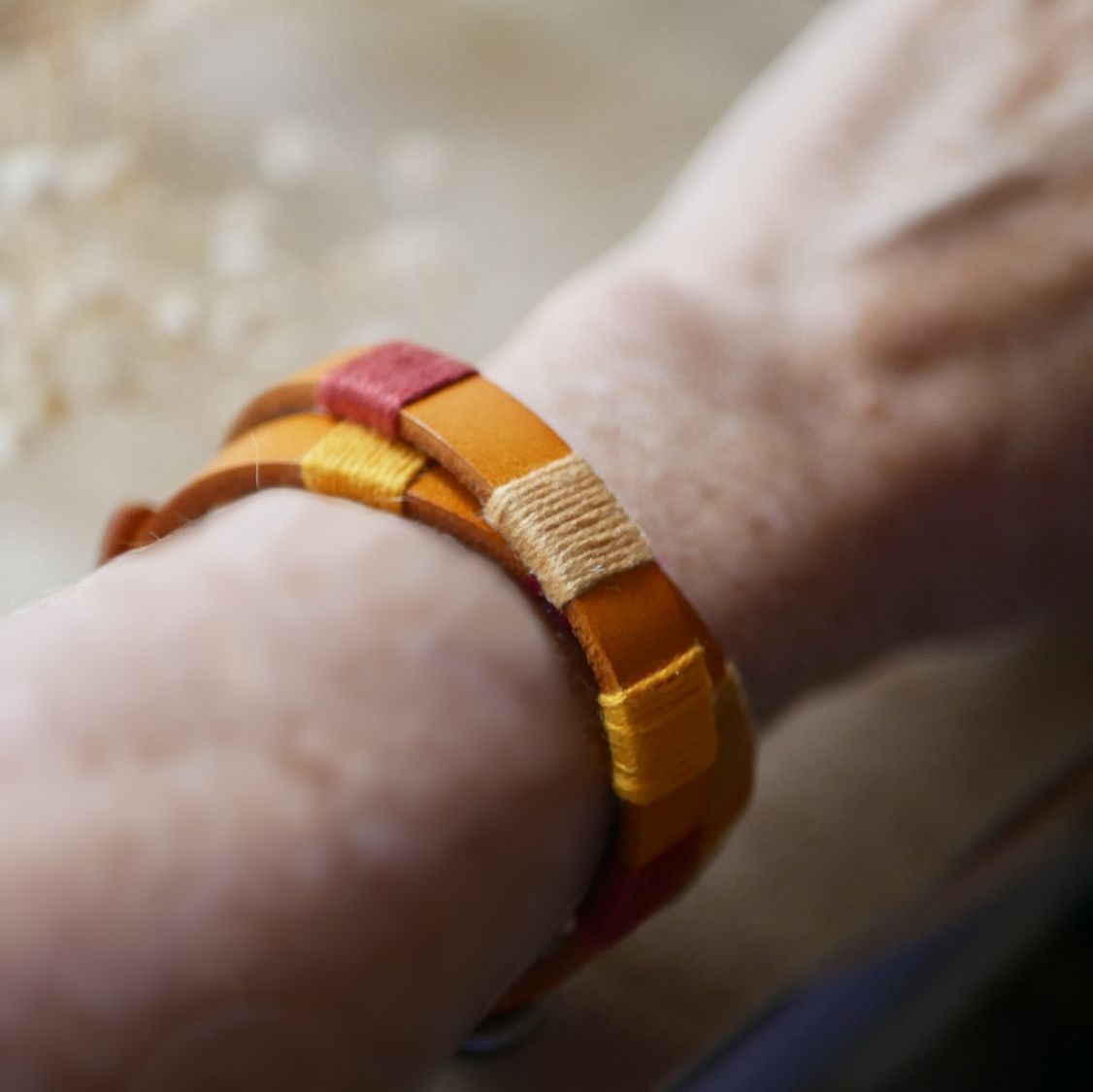 Bracelet en cuir double tour style bohème tissé de fils de coton tons oranges rouges