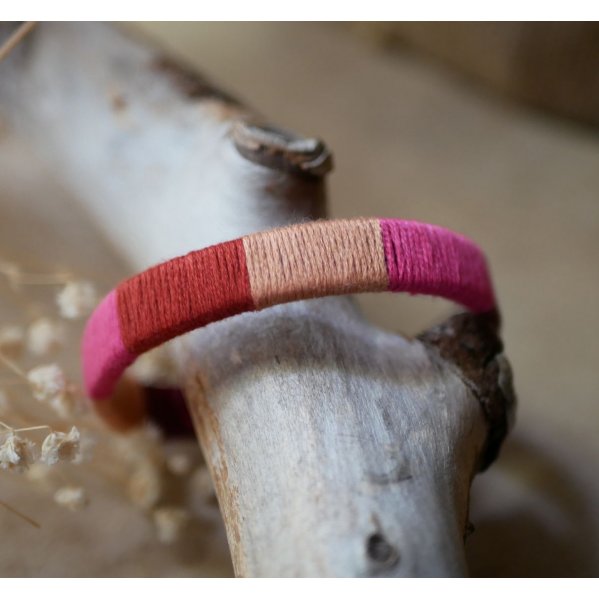Bracelet en cuir fuchsia style boh&egrave;me tiss&eacute; de fils de coton tons p&ecirc;ches et roses