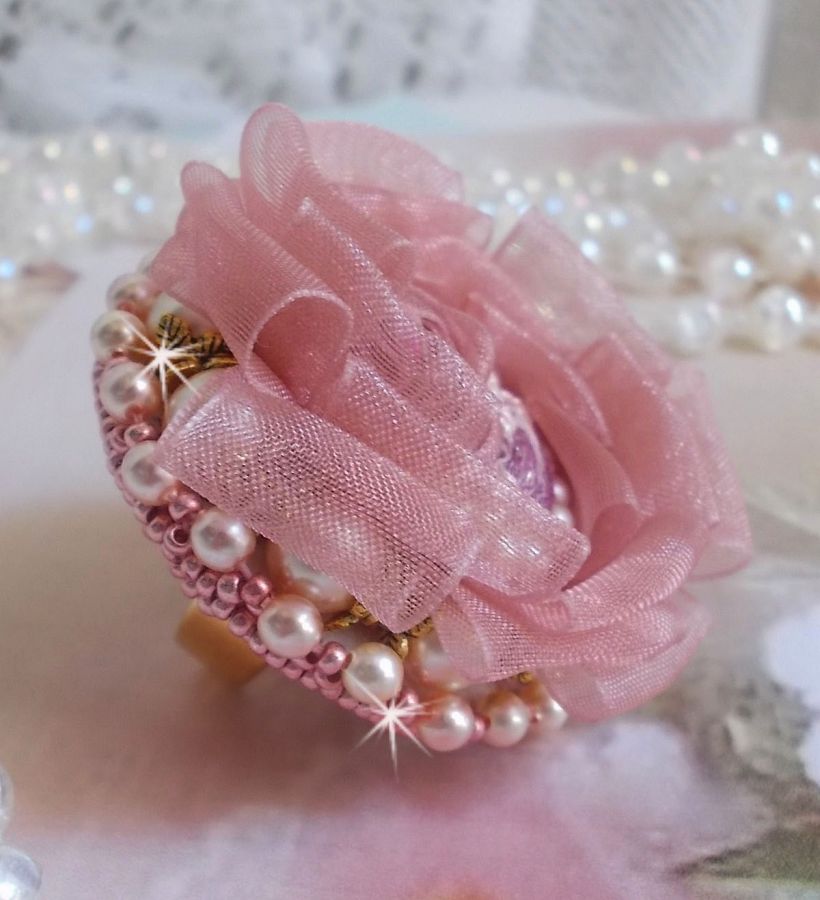 Der Ring Douceur Poudrée Haute-Couture wurde mit feinster Spitze, Organzaband Vieux Rose Antique, Swarovski-Kristallen und Miyuki Rocailles kreiert.