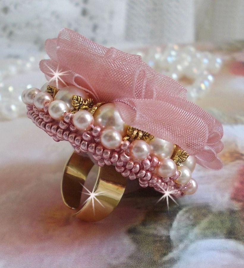 Der Ring Douceur Poudrée Haute-Couture wurde mit feinster Spitze, Organzaband Vieux Rose Antique, Swarovski-Kristallen und Miyuki Rocailles kreiert.