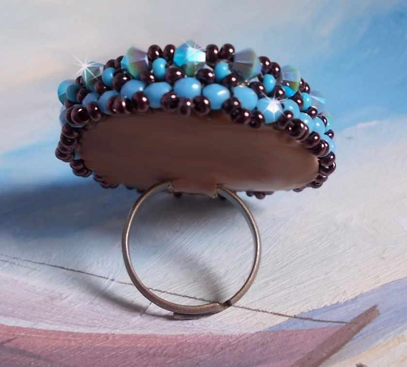 Bestickter Naïade Ring mit einem Cabochon in türkisblauem Harz und Kristall, ein schönes Lichtspiel.