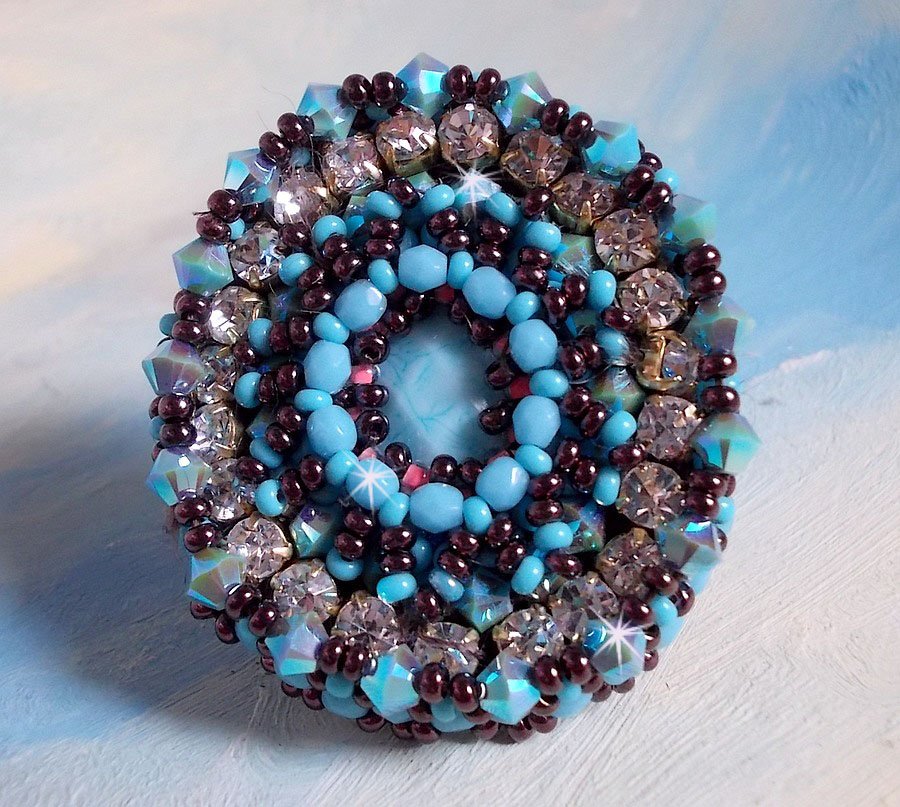 Bestickter Naïade Ring mit einem Cabochon in türkisblauem Harz und Kristall, ein schönes Lichtspiel.