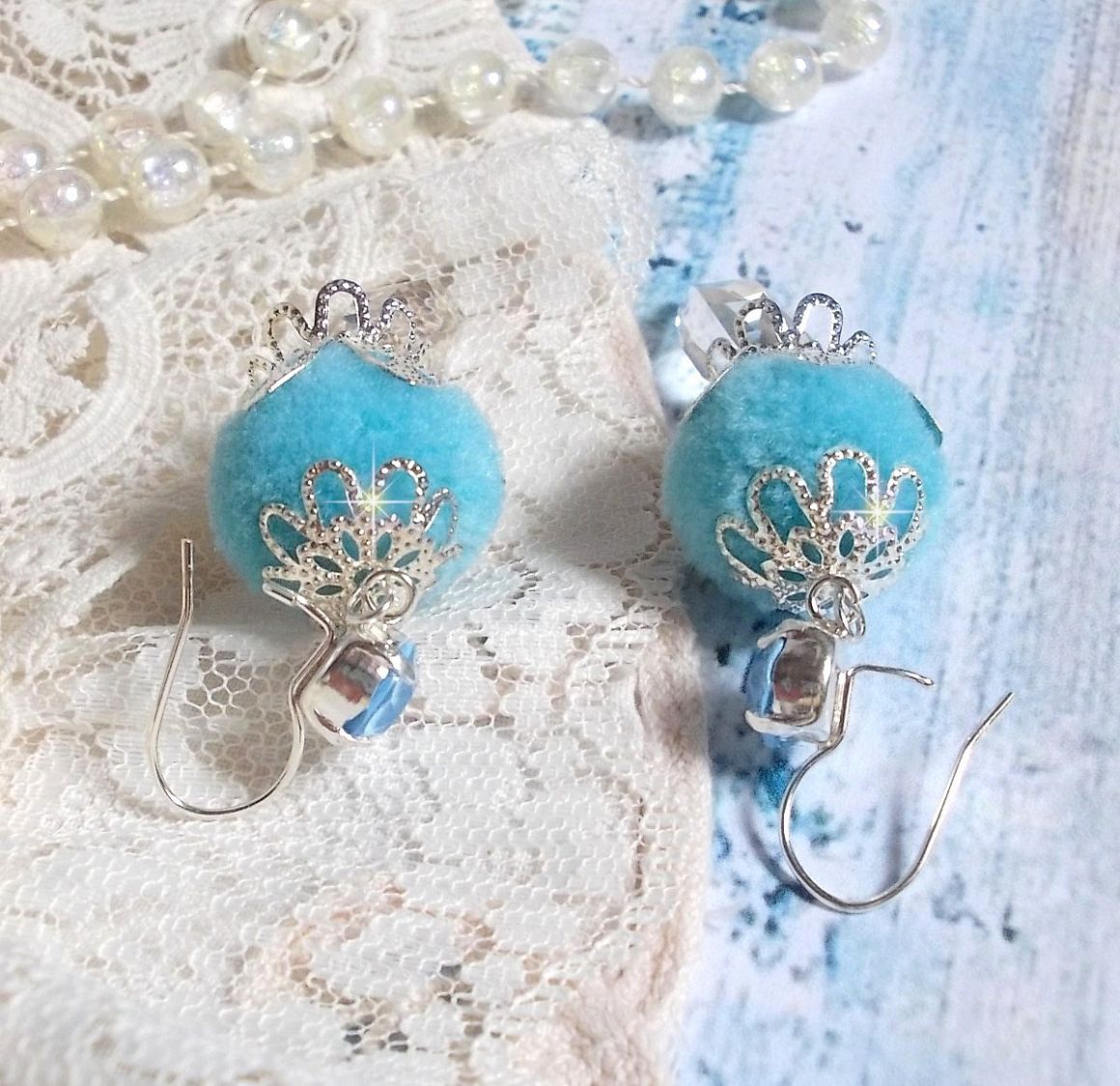 BO Azurée Blue avec des pompons Bleu Ciel à laquelle j’ai ajouté des cabochons, des gouttes torsadées en Cristal de Swarovski et des coupelles argentées. Montés sur des crochets en Argent 925/1000