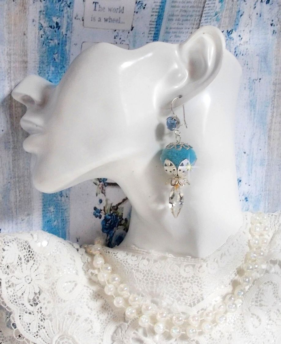 BO Azurée Blue avec des pompons Bleu Ciel à laquelle j’ai ajouté des cabochons, des gouttes torsadées en Cristal de Swarovski et des coupelles argentées. Montés sur des crochets en Argent 925/1000