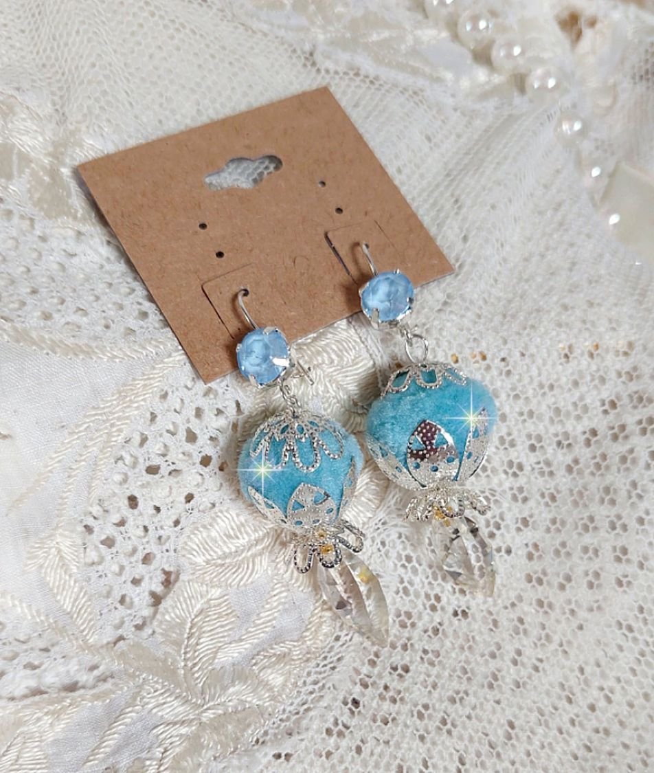 BO Azurée Blue avec des pompons Bleu Ciel à laquelle j’ai ajouté des cabochons, des gouttes torsadées en Cristal de Swarovski et des coupelles argentées. Montés sur des crochets en Argent 925/1000