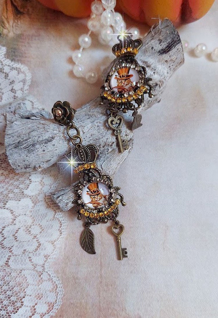 BO Chatibo Steampunk montées avec cabochons ronds en verre représentant un chat chapeauté Haute de Forme Orange. Strassées avec une couronne, breloques clés et feuilles. Montées sur clips Bronze