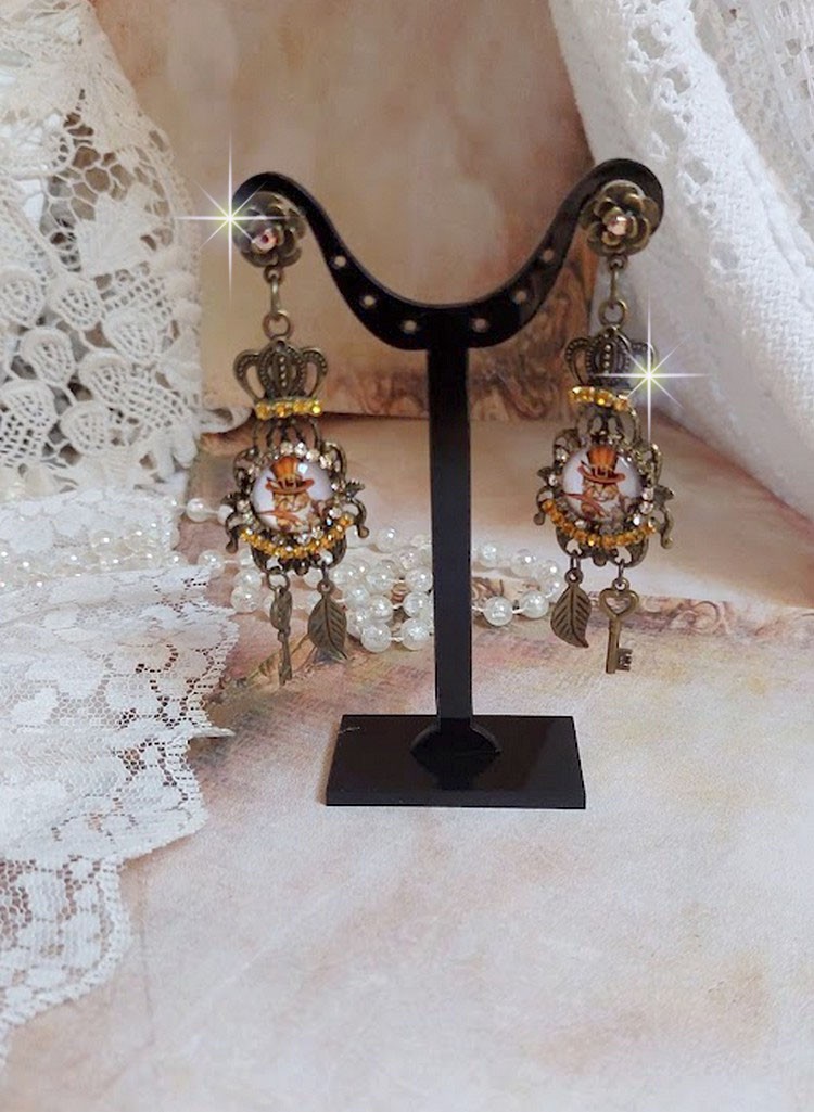 BO Chatibo Steampunk montées avec cabochons ronds en verre représentant un chat chapeauté Haute de Forme Orange. Strassées avec une couronne, breloques clés et feuilles. Montées sur clips Bronze