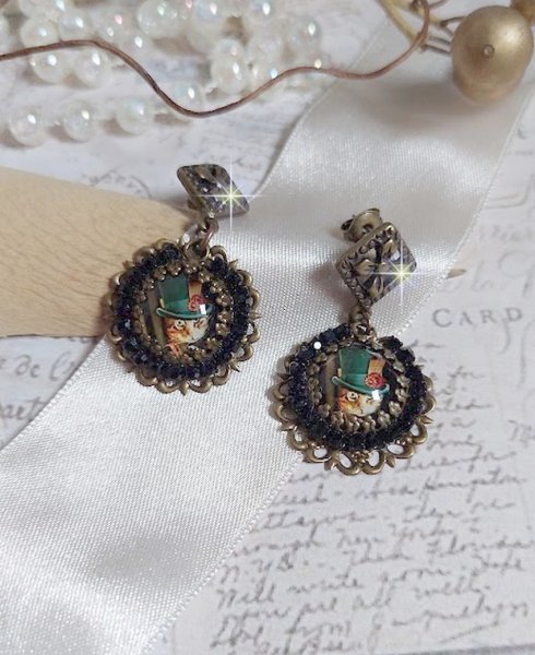 BO Chatou Steampunk mont&eacute;es avec cabochons loupes repr&eacute;sentant des chats en chapeau haut de forme Vert avec un m&eacute;daillon orn&eacute;s d&rsquo;une cha&icirc;ne strass Noire sur estampes Bonze et clous d'oreilles Laiton