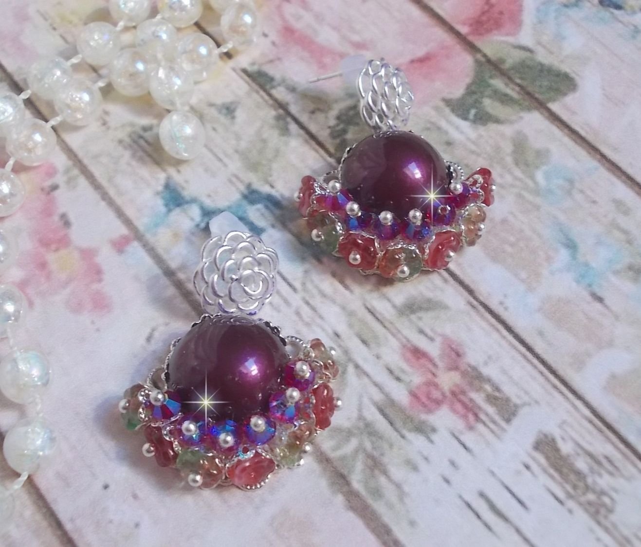 BO Fleurs de Cabaret avec des cabochons ronds Bordeaux en cristal de Swarovski, des toupies Fuschia, des fleurs clochettes en verre sur une base pendentif argentée et des clous d'oreilles en métal