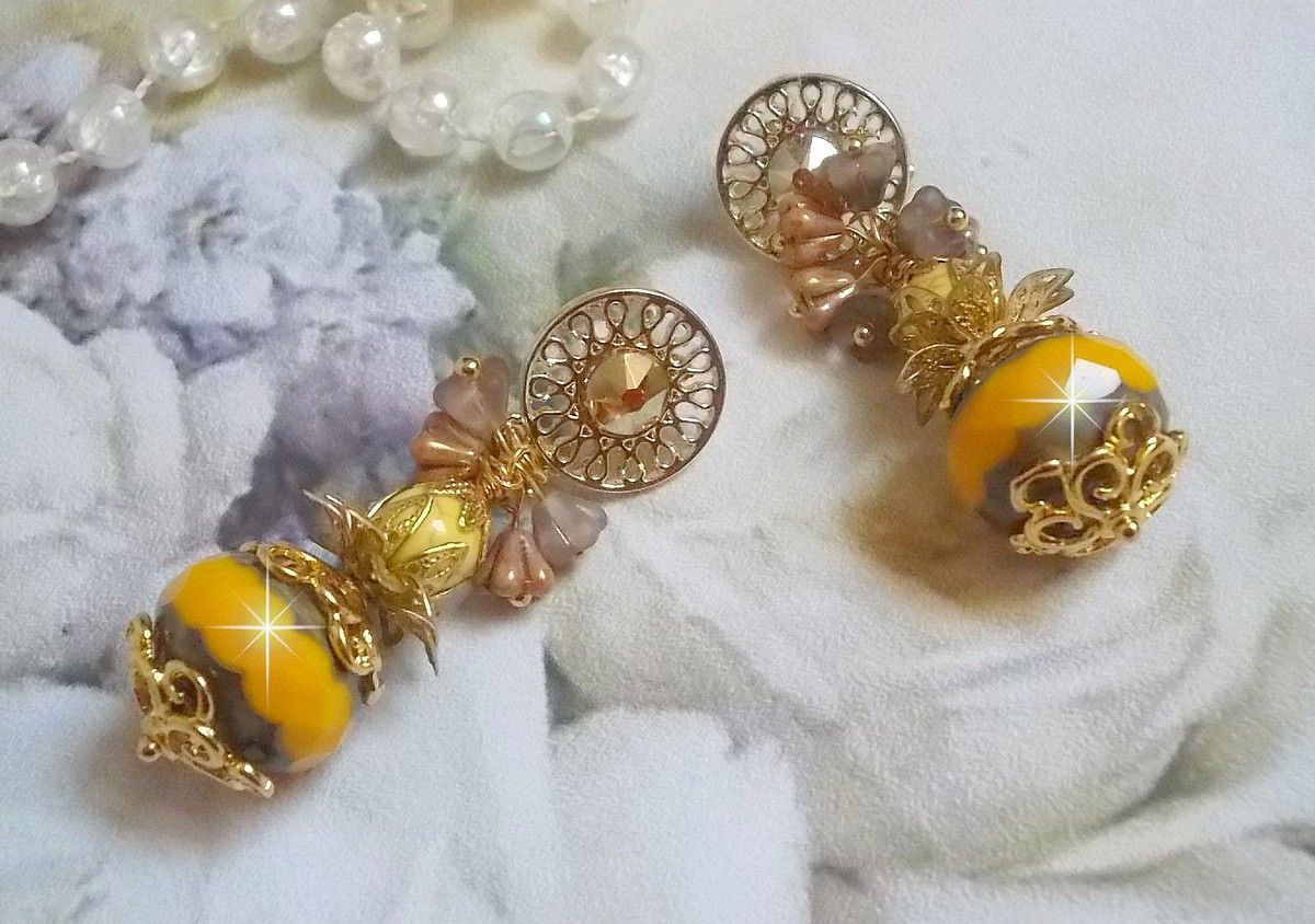 BO Lumière Opale Jaune avec des perles potirons jaunes à laquelle s’ajoute des fleurs, cabochons en cristal, coupelles et perles rondes. Montés sur clous d’oreilles en Métal. Un style moderne