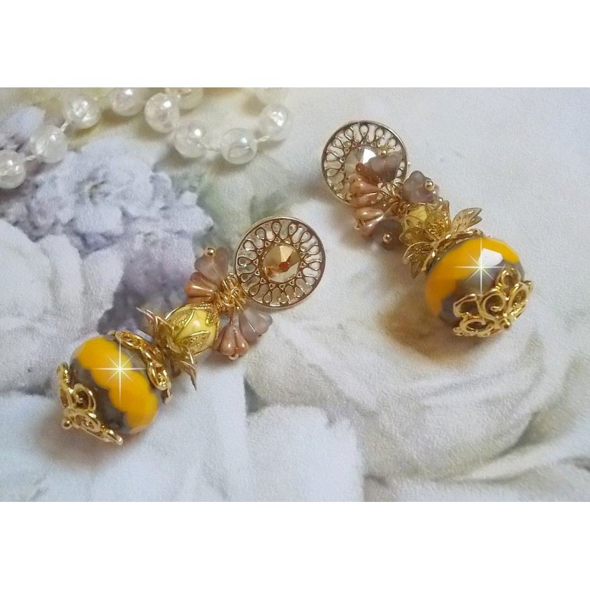 BO Lumière Opale Jaune avec des perles potirons jaunes à laquelle s’ajoute des fleurs, cabochons en cristal, coupelles et perles rondes. Montés sur clous d’oreilles en Métal. Un style moderne