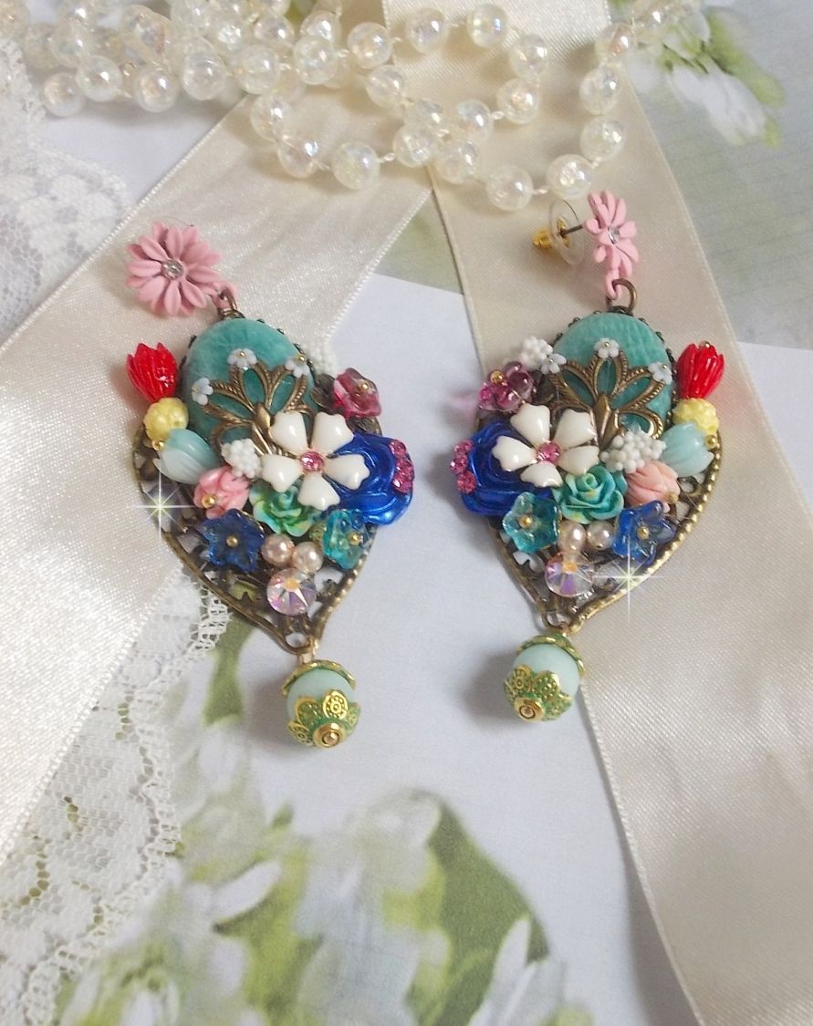 BO Majestueuses sur des estampes gouttes avec des cabochons aux fleurs vert, or, jaune, rouge, ivoire, cristal, rose et blanc. Les cristaux accompagnent l’ensemble des cabochons et perles en Amazonite