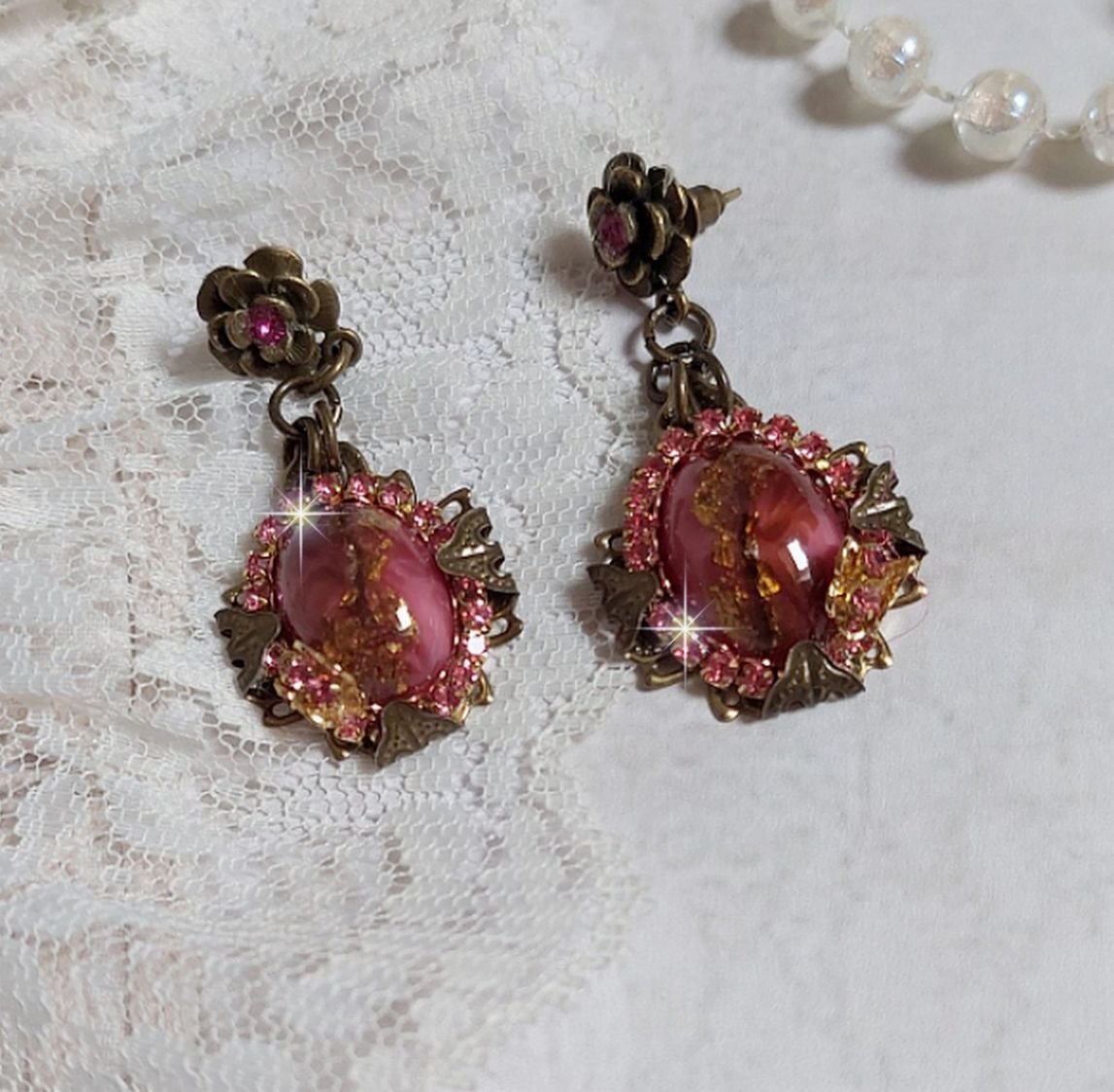 BO Pampelone Fuchsia avec cabochons ovales aux feuilles d’or ornées de strass, cristaux, Roses et breloques papillons. Montées sur des estampes carrées et des clous d’oreilles Bronze en Métal