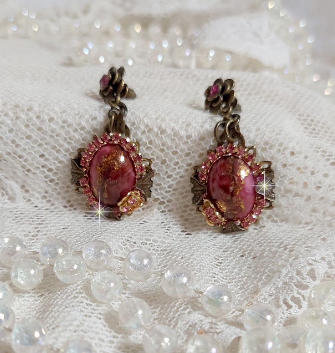 BO Pampelone Fuchsia avec cabochons ovales aux feuilles d’or ornées de strass, cristaux, Roses et breloques papillons. Montées sur des estampes carrées et des clous d’oreilles Bronze en Métal