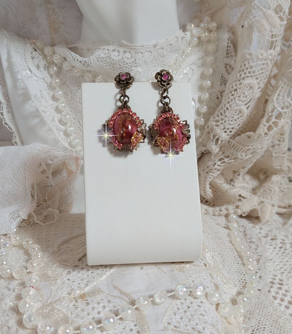 BO Pampelone Fuchsia avec cabochons ovales aux feuilles d’or ornées de strass, cristaux, Roses et breloques papillons. Montées sur des estampes carrées et des clous d’oreilles Bronze en Métal