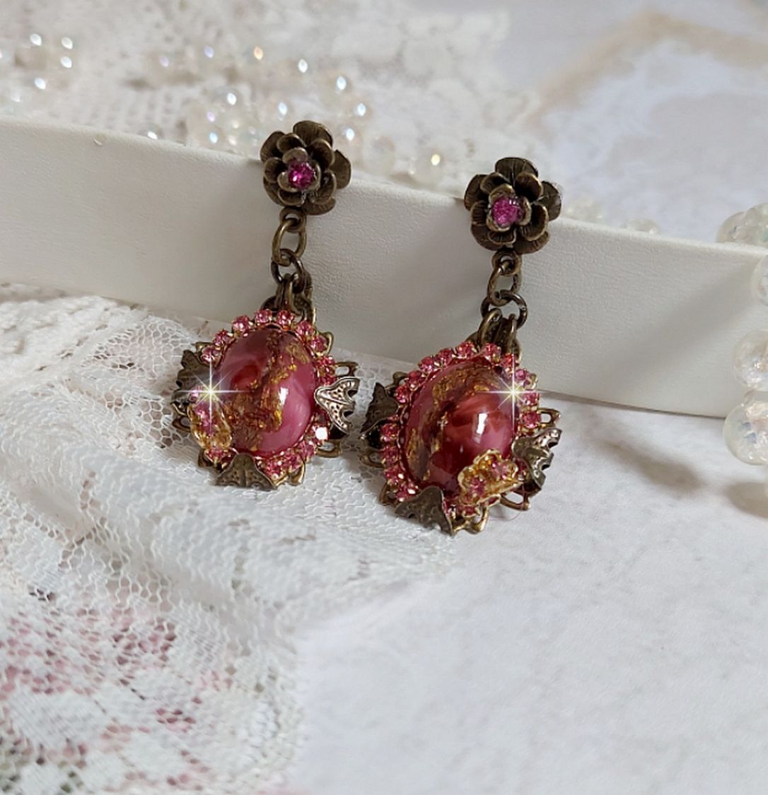 BO Pampelone Fuchsia avec cabochons ovales aux feuilles d’or ornées de strass, cristaux, Roses et breloques papillons. Montées sur des estampes carrées et des clous d’oreilles Bronze en Métal