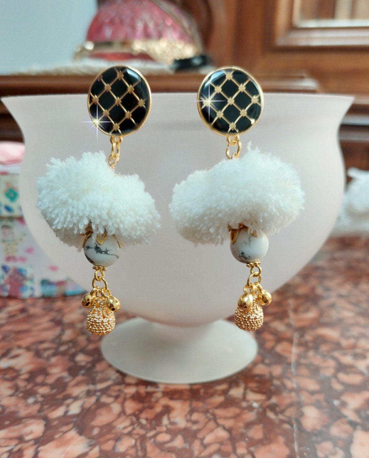 BO Cassandre avec des pierres de gemme : le Howlite Blanc &agrave; laquelle s&rsquo;ajoute des pompons, des intercalaires rondelles, des coupelles feuilles et breloques. Mont&eacute;s sur des puces Noires et Dor&eacute;es 