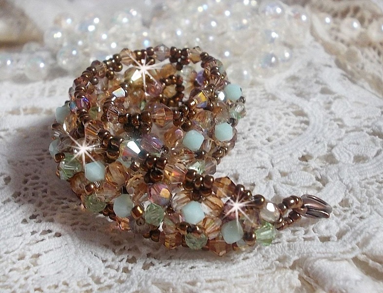 Seerosenarmband, ein wassergr&uuml;ner und goldener Schimmer mit diesen Kreiseln in Swarovski-Kristall und Facetten in b&ouml;hmischem Glas.