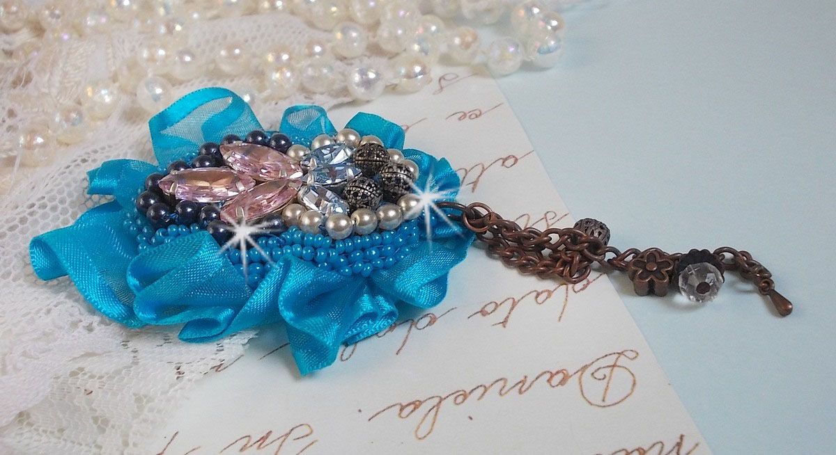 Belle Epoque Haute-Couture Brosche ist mit Swarovski-Kristallen, runden Perlmuttperlen, Charms, einem Band und Rocailles bestickt.