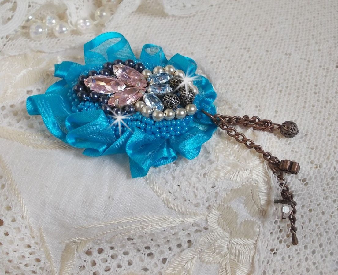 Belle Epoque Haute-Couture Brosche ist mit Swarovski-Kristallen, runden Perlmuttperlen, Charms, einem Band und Rocailles bestickt.