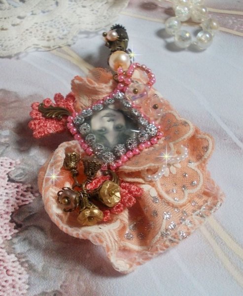 Rustic Rose Brosche mit einem Cabochon, der ein l&auml;chelndes M&auml;dchen darstellt, orangefarbener Strass- und Rosenspitze, Kristallen, Glasperlen und verschiedenen Accessoires.