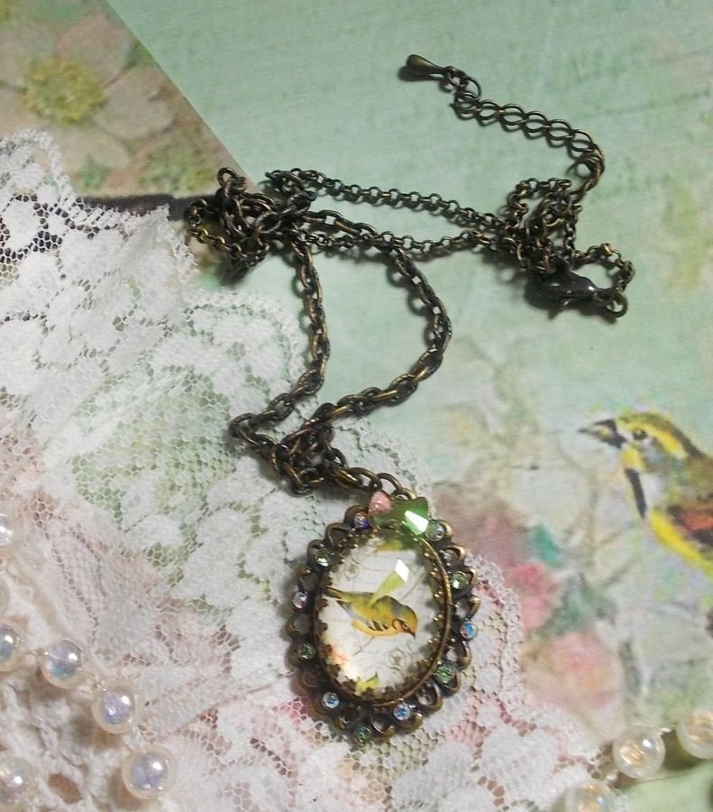 Gartenvogel-Halskette mit einem Lupen-Cabochon und Kristallen auf bronzefarbenen Accessoires.