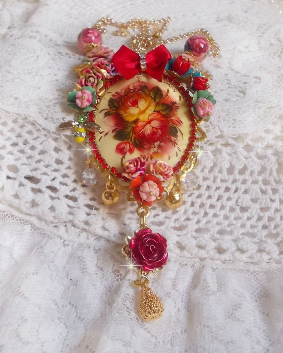 Collier Roseraie Provençale crée avec des perles en verre, céramique, résine, des accessoires en plaqué Or et autres avec un nœud en satin Rouge