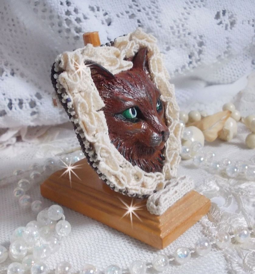 Masque Chat Rocky aux Yeux Verts tout en Fimo brodé avec un dentelle beige très fine, des perles rondes nacrées en Cristal de Swarovski, de la peinture et des rocailles