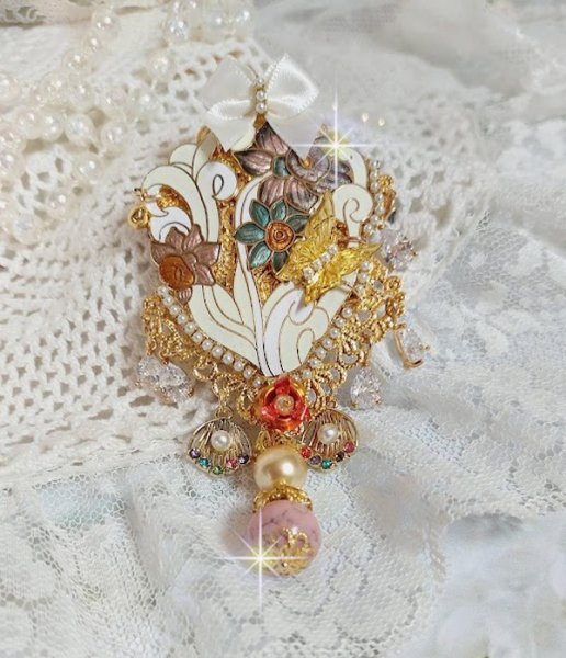 Pendentif Aurore monté avec un motif émaillé aux couleurs du soleil à laquelle s’ajoute perles nacrées, breloques, poires avec Zircons, perles, ruban sur une bélière Argent 925 et une chaîne plaqué Or