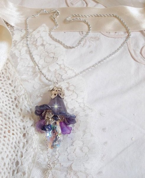 Pendentif Eclat de Cristal mont&eacute; avec une goutte en Cristal, fleurs en Verre, fleurs lucites dont une plus grande peinte &agrave; la main avec paillettes Argent&eacute;es. Une composition florale