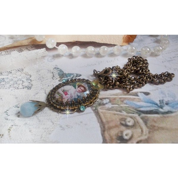 Pendentif Douce Dame créé avec un cabochon représentant une femme au chapeau blanc orné de cristaux, des accessoires de couleur Bronze et un jade teinté bleu 