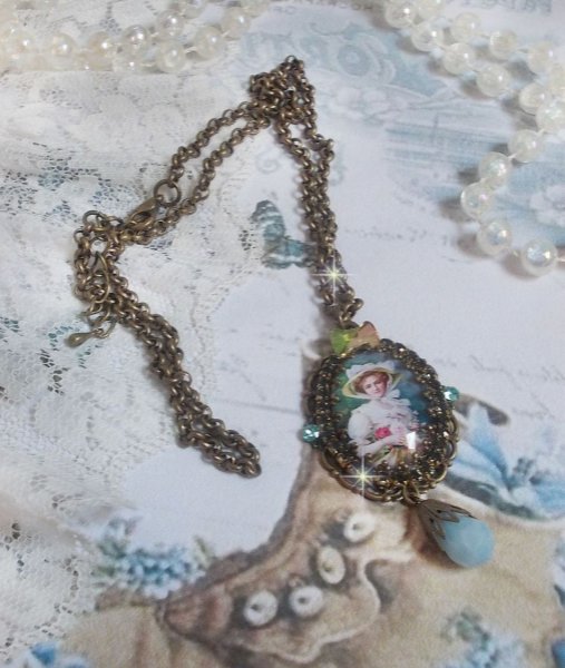 Pendentif Douce Dame cr&eacute;&eacute; avec un cabochon repr&eacute;sentant une femme au chapeau blanc orn&eacute; de cristaux, des accessoires de couleur Bronze et un jade teint&eacute; bleu 