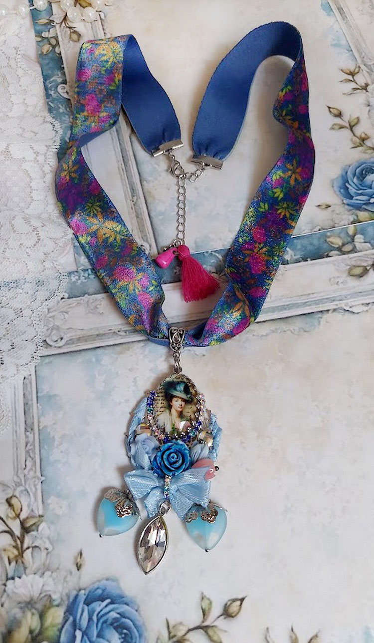 Pendentif Infiniment Bleuté créé avec fleurs synthétiques, résine, cabochon verre, ruban velours et perles Cristal Swarovski