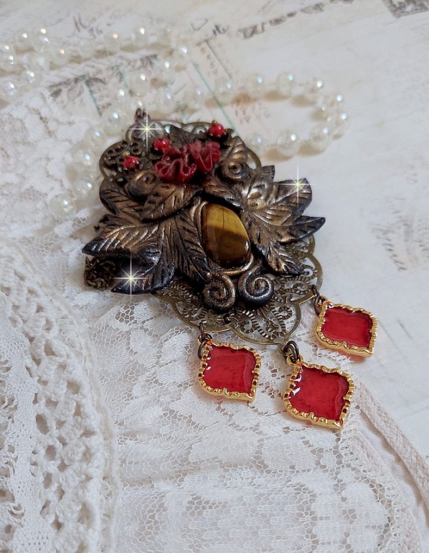 Pendentif Mélodie avec un cabochon Œil de tigre orné de perles en Jade Rouge veiné de Noir sur fleurs 5 pétales et estampes montés sur une chaîne bronze. Les pendants sont en résine époxy Rouge