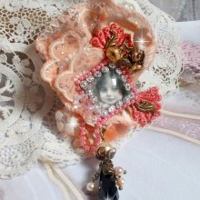 Rustic Rose Brosche mit einem Cabochon, der ein lächelndes Mädchen darstellt, orangefarbener Strass- und Rosenspitze, Kristallen, Glasperlen und verschiedenen Accessoires.