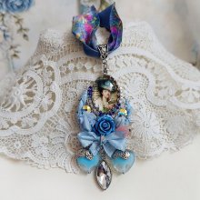 Pendentif Infiniment Bleuté créé avec fleurs synthétiques, résine, cabochon verre, ruban velours et perles Cristal Swarovski