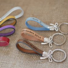 Schlüsselanhänger aus Leder zu personalisieren durch Gravur mit einer Fliege geschmückt