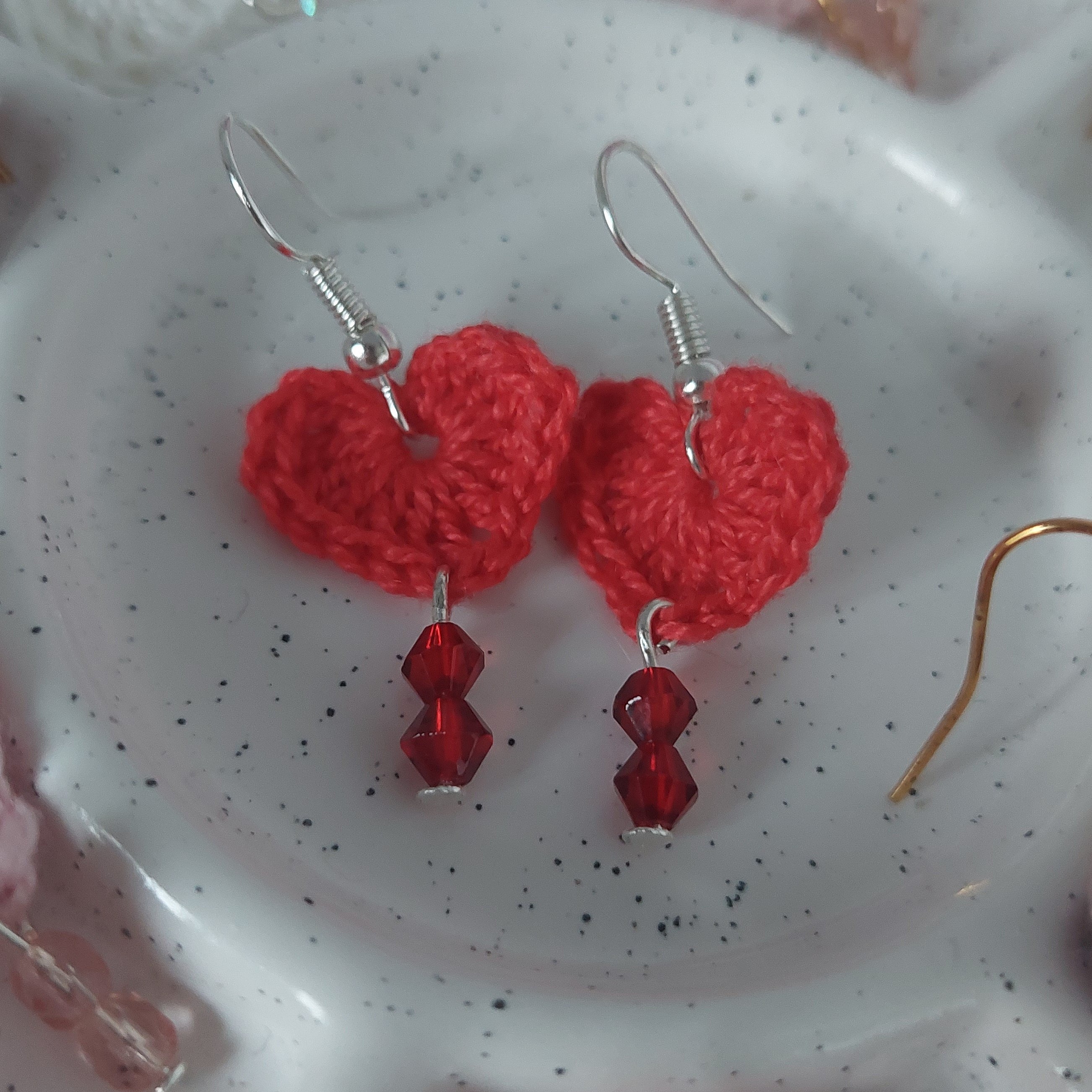 Boucles d'oreilles cœurs en crochet avec perles colorées.