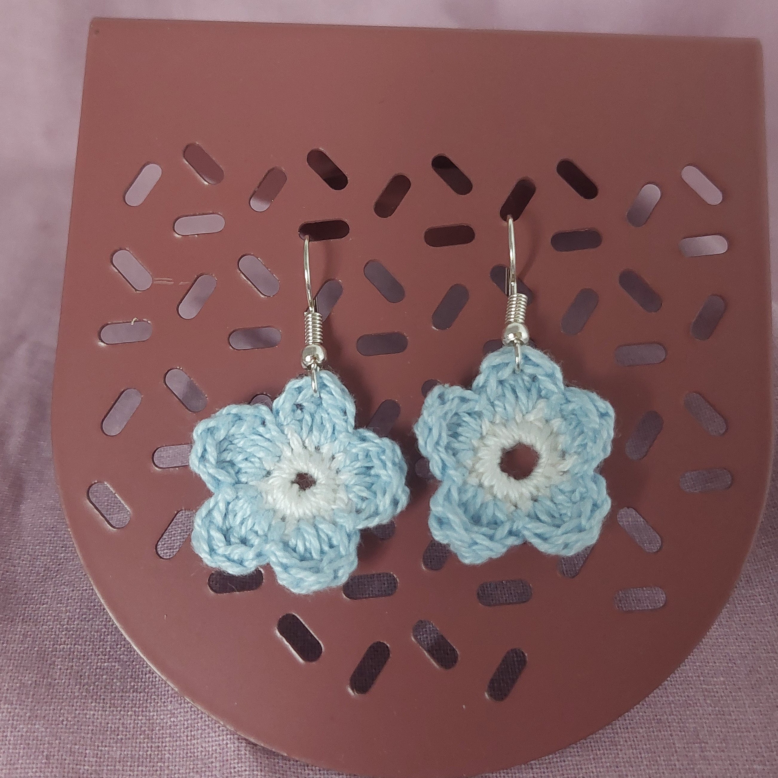 Boucles d'oreilles en forme de fleurs réalisées au crochet.